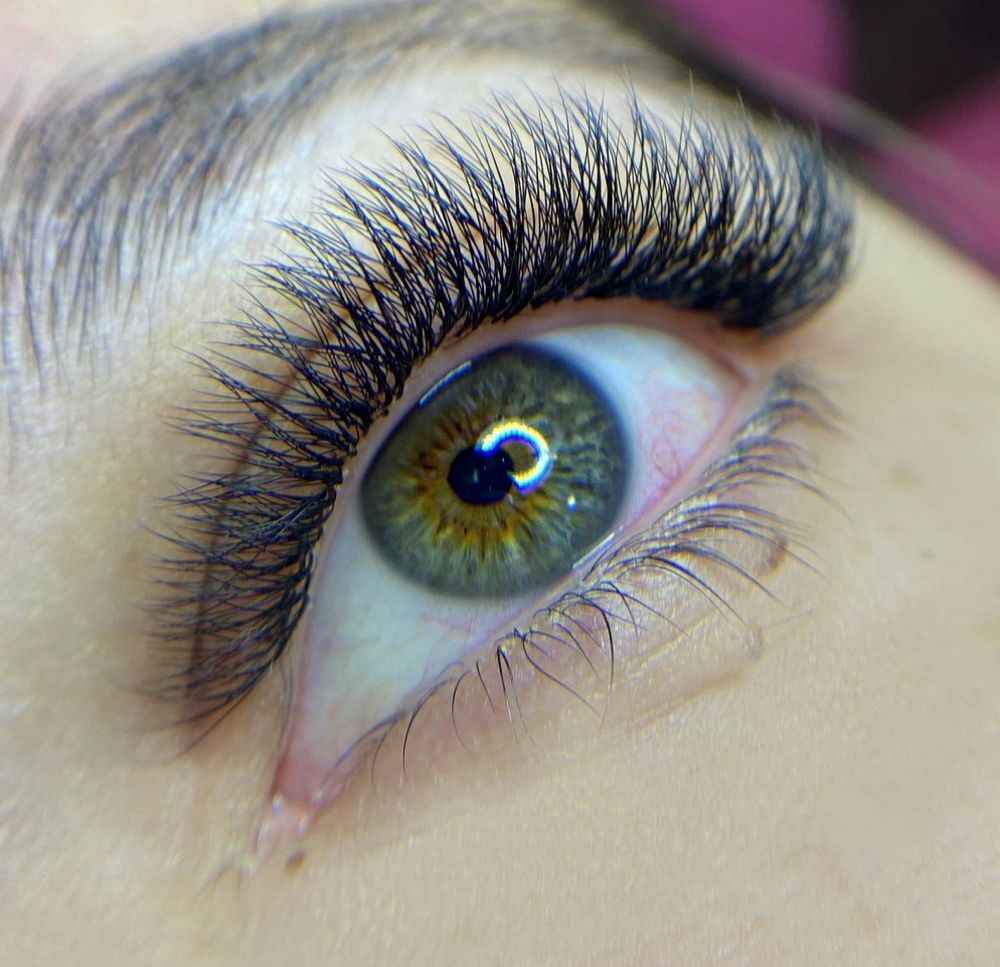 A close up of a woman 's eye with long eyelashes.