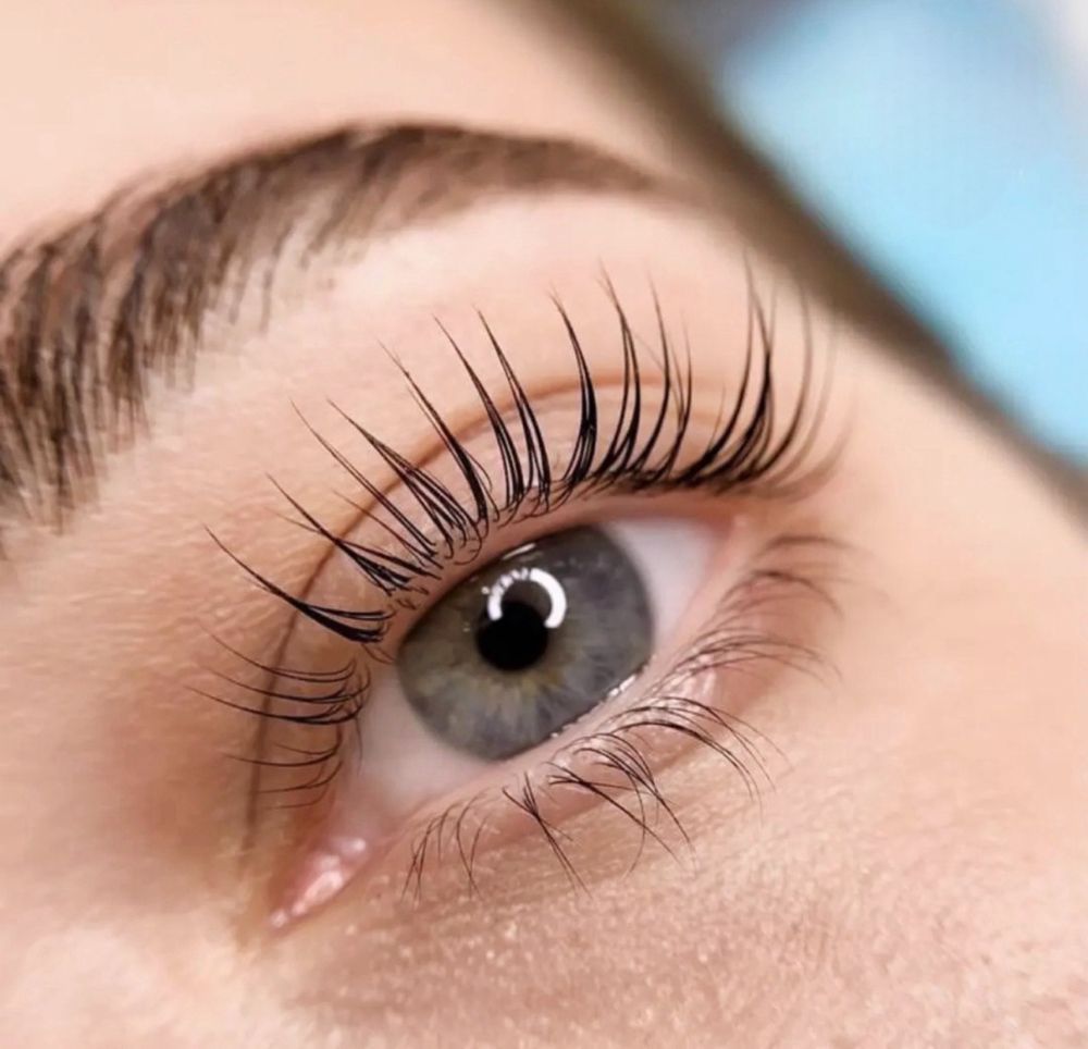 A close up of a woman 's eye with long eyelashes.