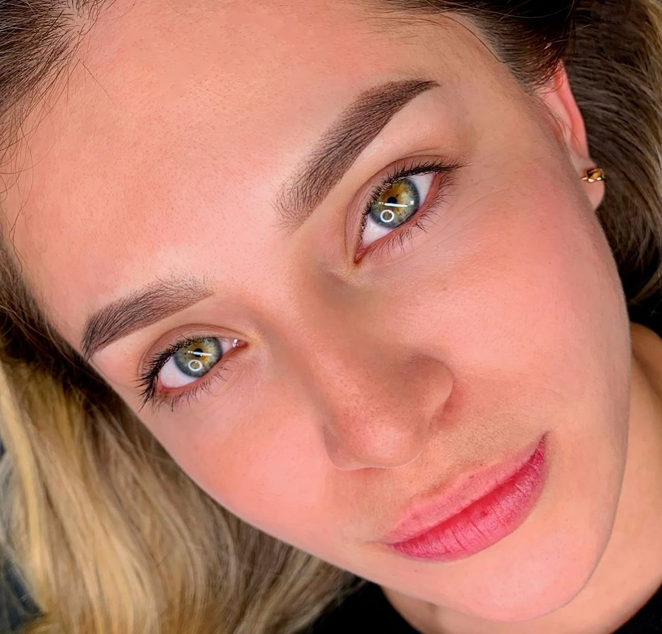 A close up of a woman 's face with green eyes