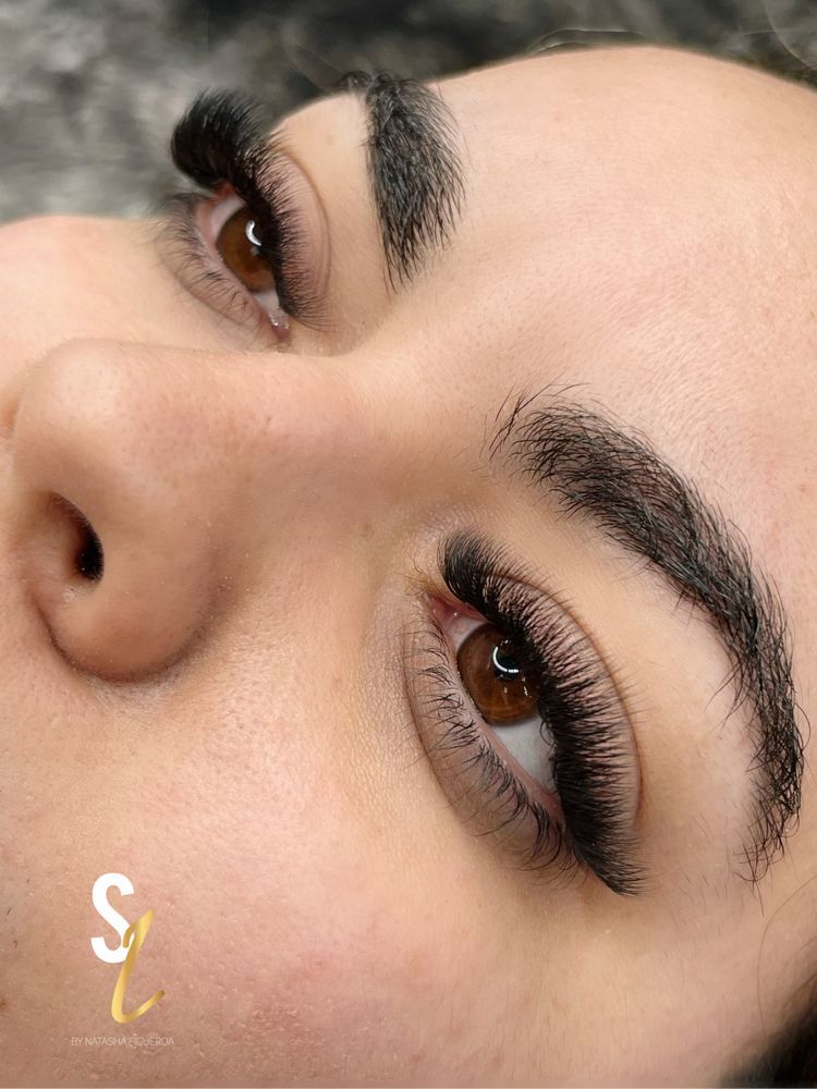 A close up of a woman 's face with long eyelashes.