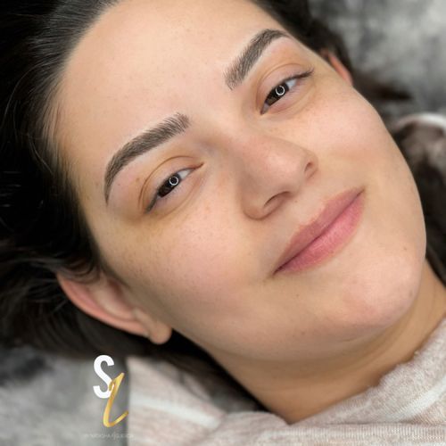 A close up of a woman 's face with a smile on her face.