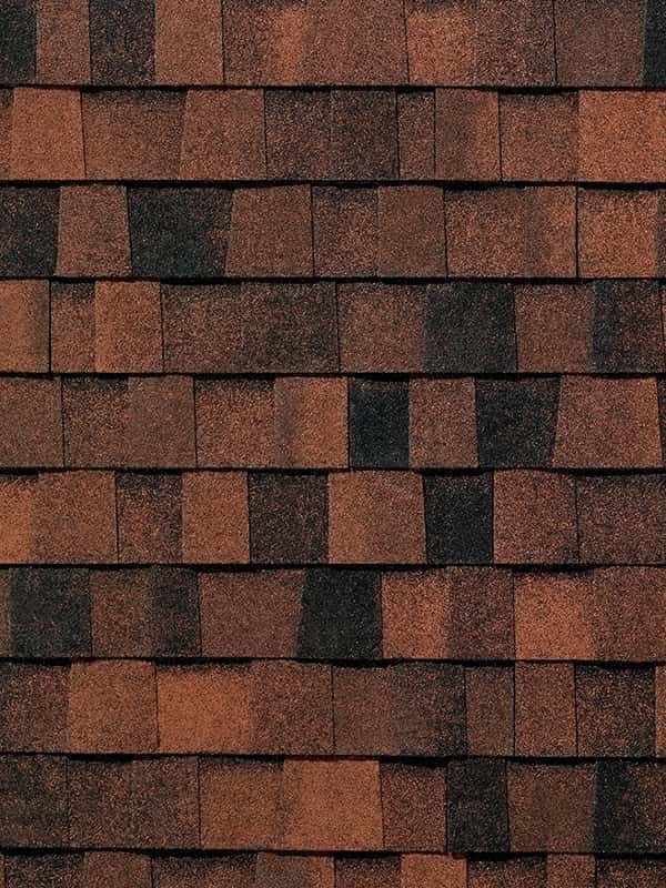 A close up of a row of brown and black shingles on a roof.
