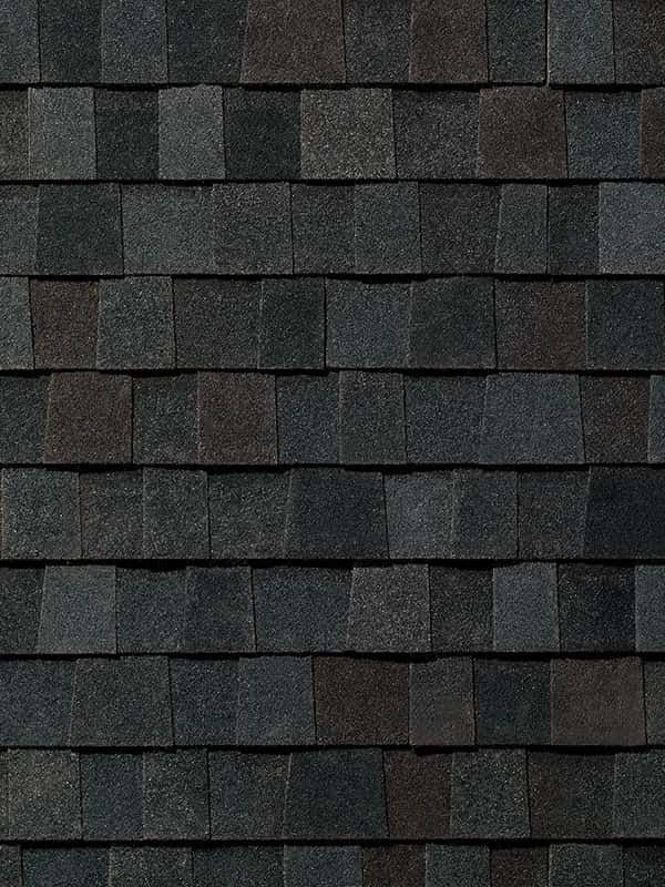A close up of a row of black shingles on a roof.