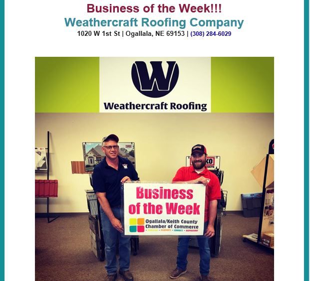 Two men holding a sign that says business of the week