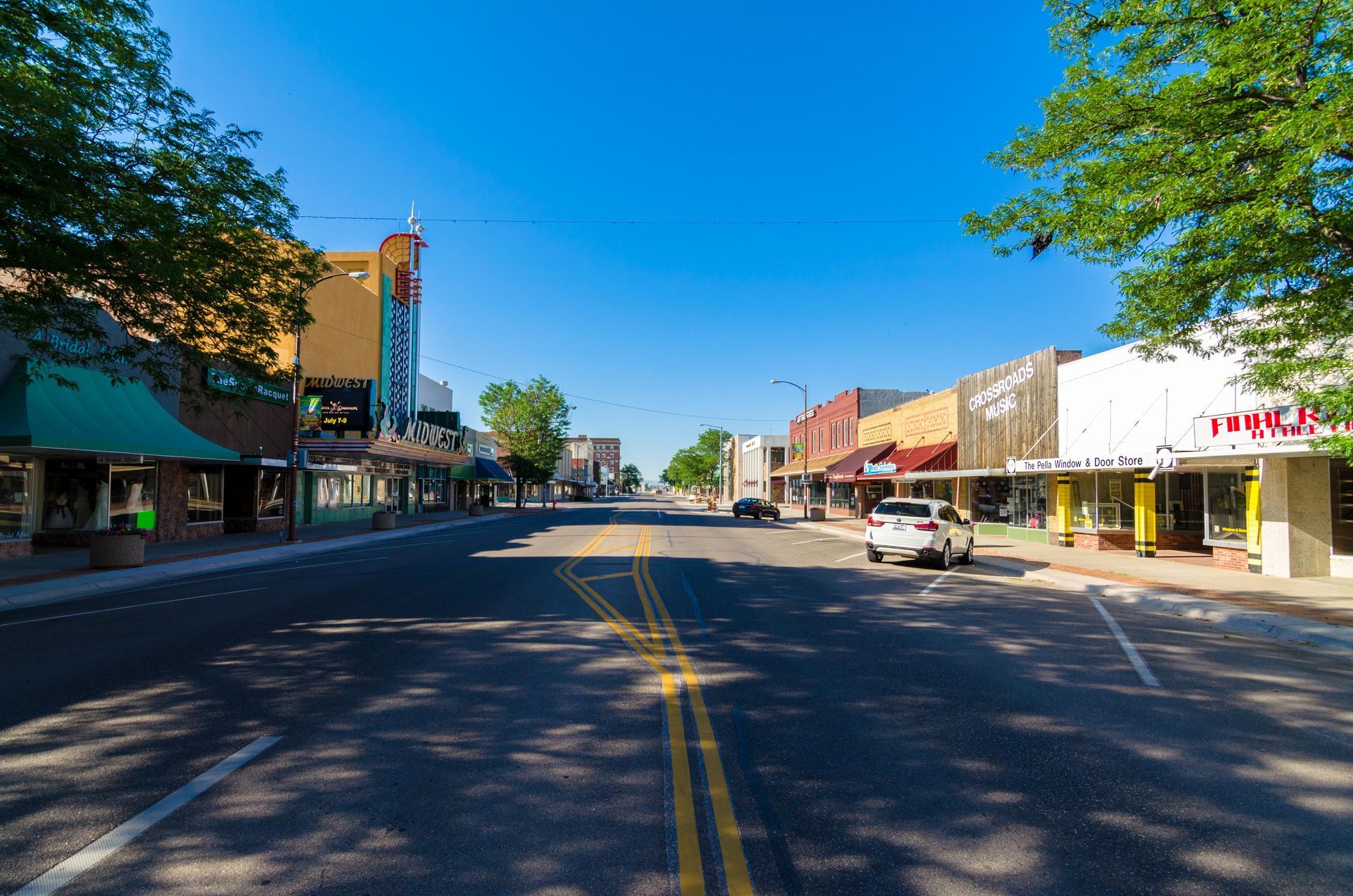 A car is driving down a street in a small town.