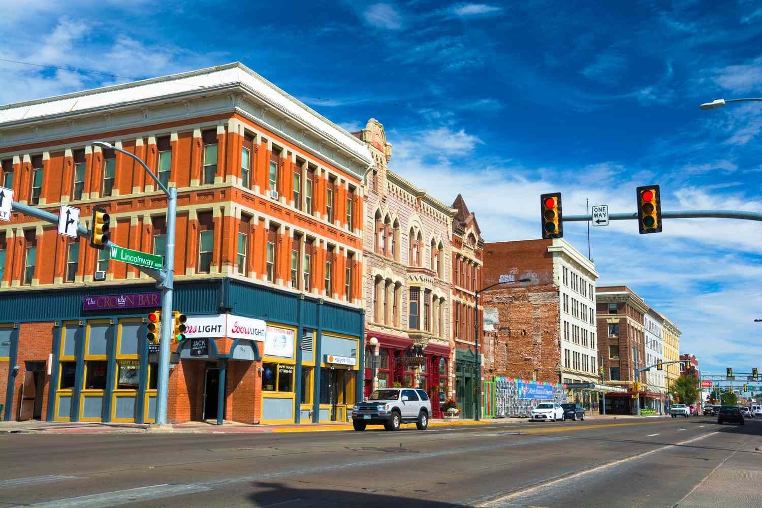 A street corner in a small town with a lot of buildings and traffic lights.