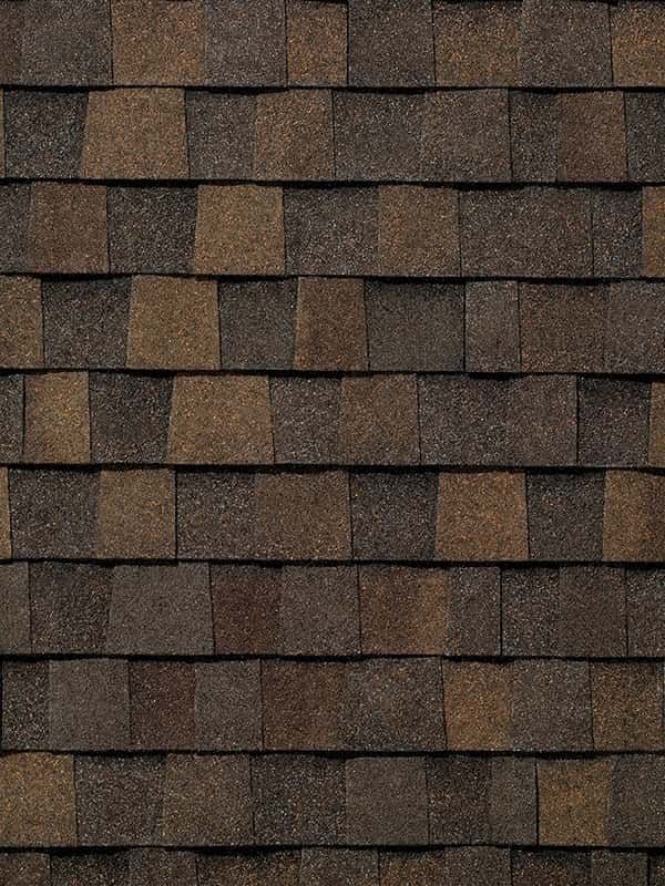 A close up of a row of brown shingles on a roof.