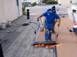 A man is working on a roof with a torch.