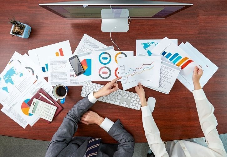 two people analyzing charts and data