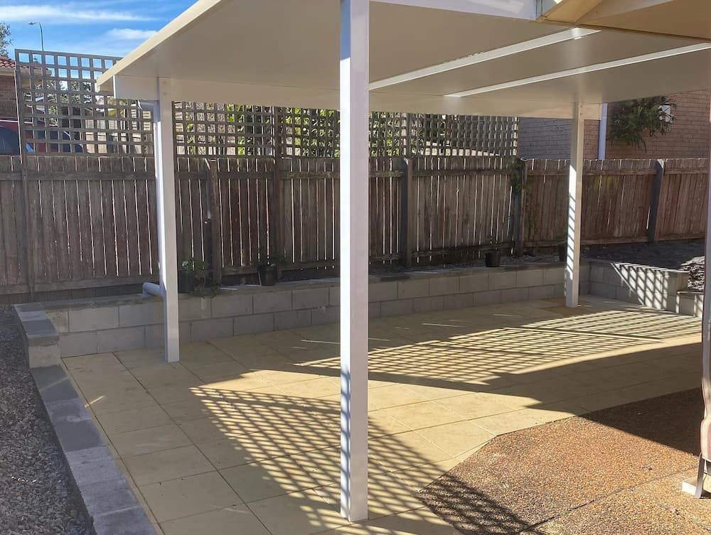 A Covered Patio With A Wooden Fence In The Background — Millers Masonry In Port Macquarie, NSW
