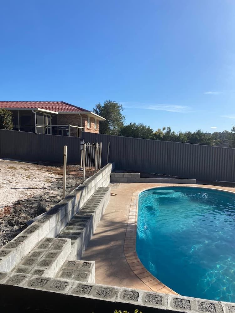There Is A Swimming Pool In The Backyard Of A House — Millers Masonry In Taree, NSW