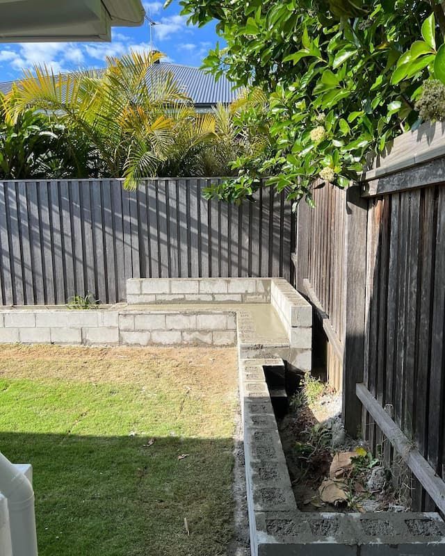 A Backyard With A Wooden Fence And A Brick Wall — Millers Masonry In Taree, NSW