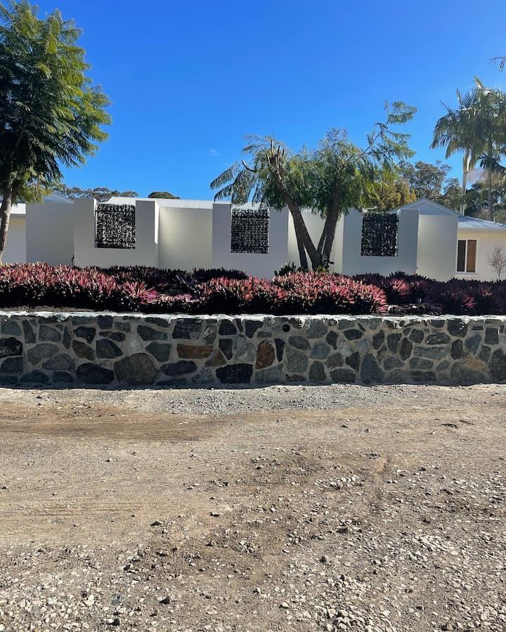 A White House With A Stone Wall In Front Of It — Millers Masonry In Port Macquarie, NSW