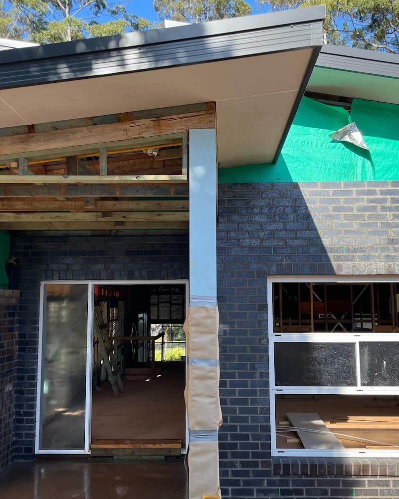 A Brick House With A Green Roof Is Being Built — Millers Masonry In Wauchope, NSW