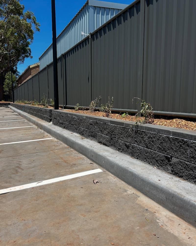 A Parking Lot With A Fence In The Background — Millers Masonry In Port Macquarie, NSW