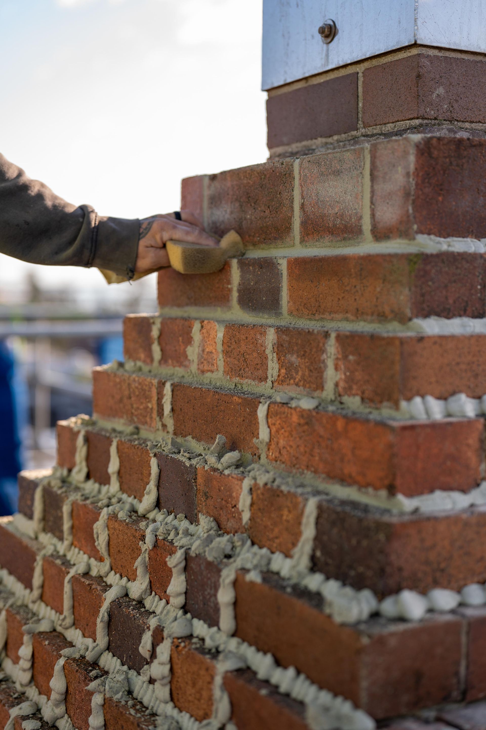 Bricklayer Smoothing Mortar on A Stepped Brick Structure — Millers Masonry In Taree, NSW