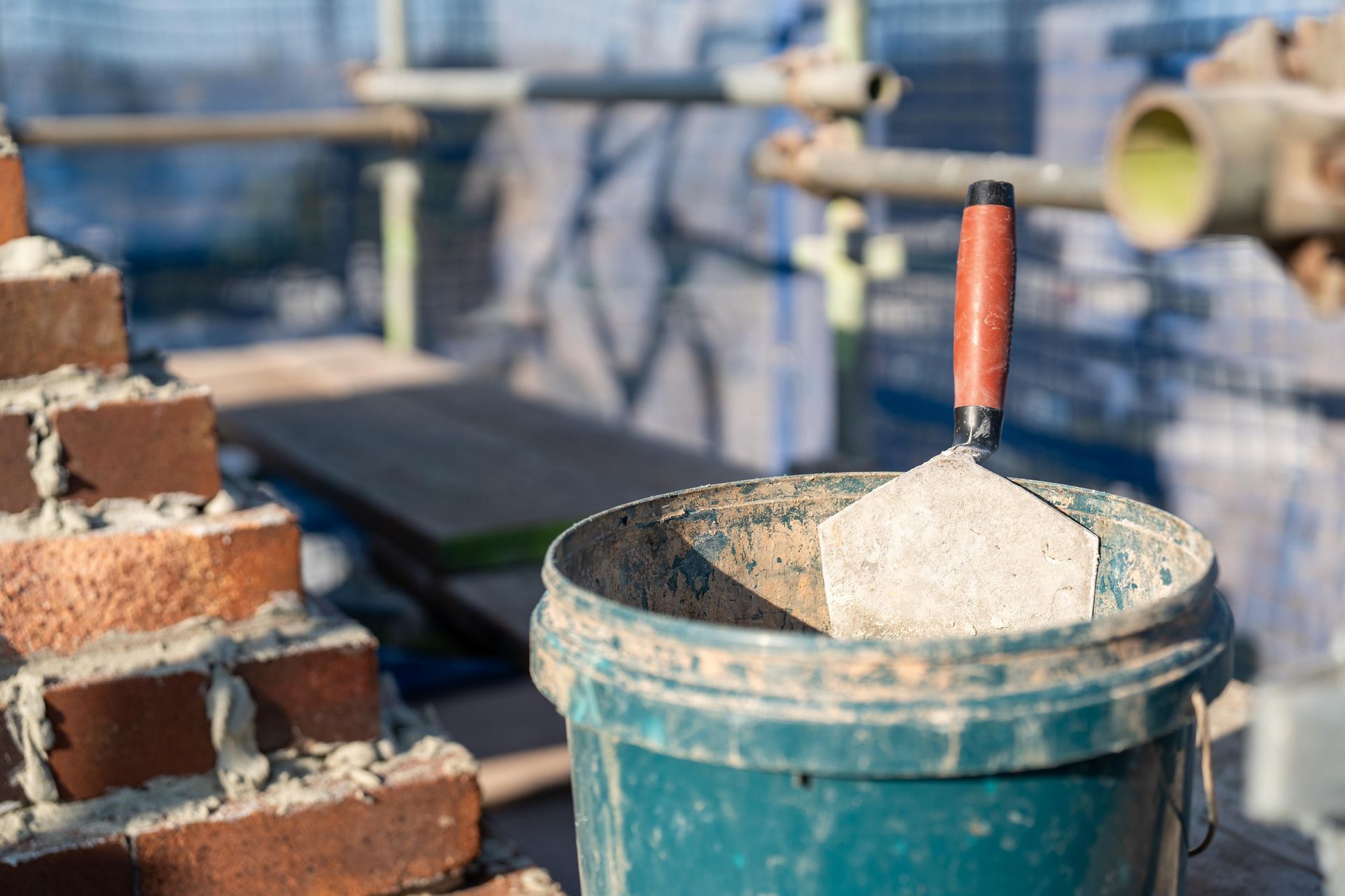 Bricklaying Tools: Trowel in Bucket of Mortar — Millers Masonry In Port Macquarie, NSW