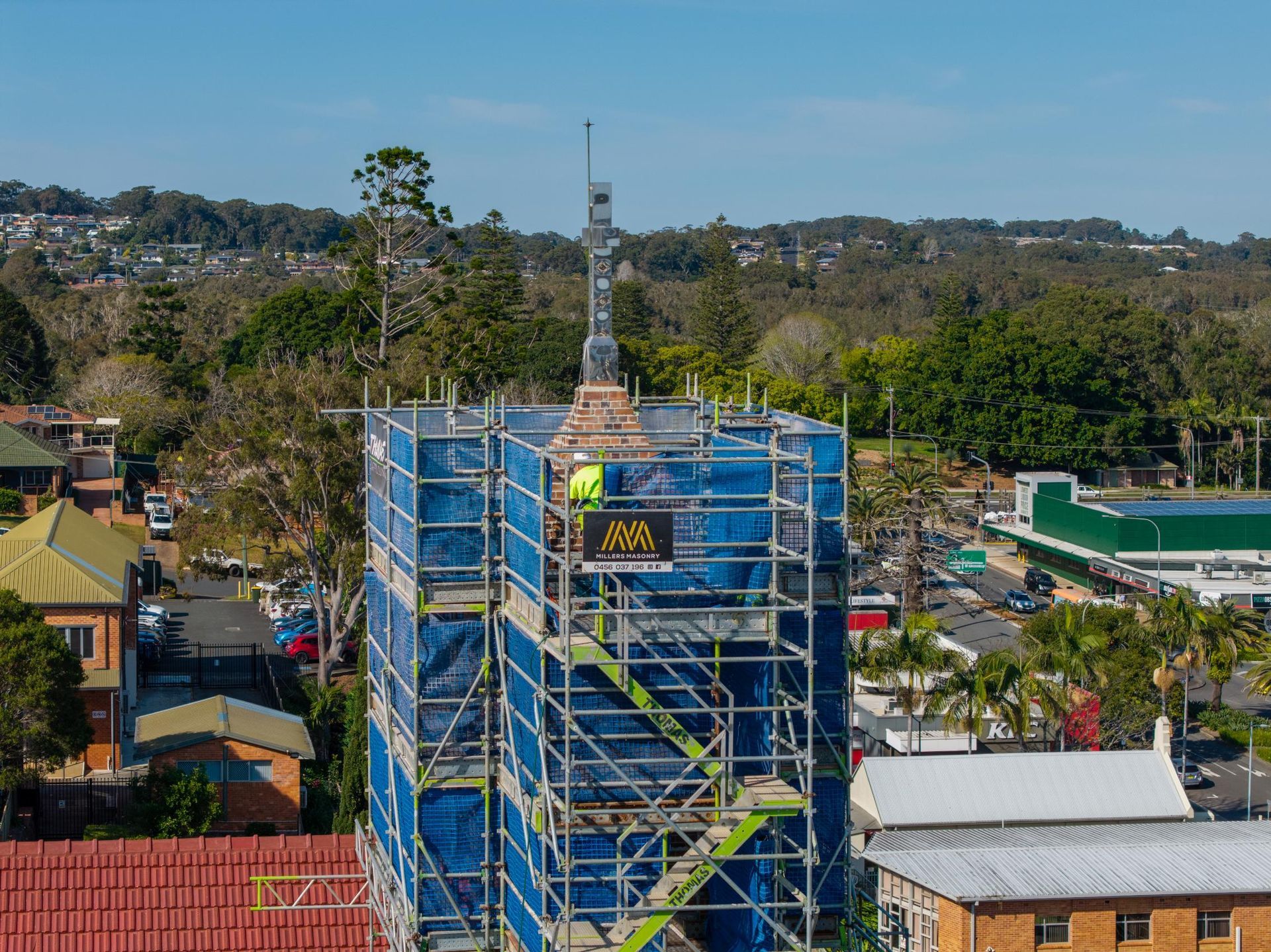 Scaffolding Surrounds a Building's Spire, Worker Visible — Millers Masonry In Kempsey, NSW