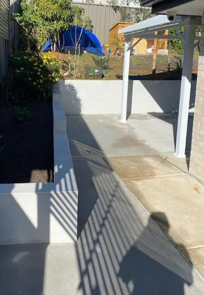 A Shadow Of A Person Is Cast On The Sidewalk In Front Of A House — Millers Masonry In Port Macquarie, NSW
