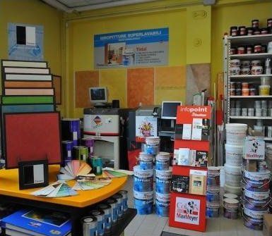 Dipingi l'interno del negozio con barattoli di vernice, campioni di colore e scaffali espositivi.