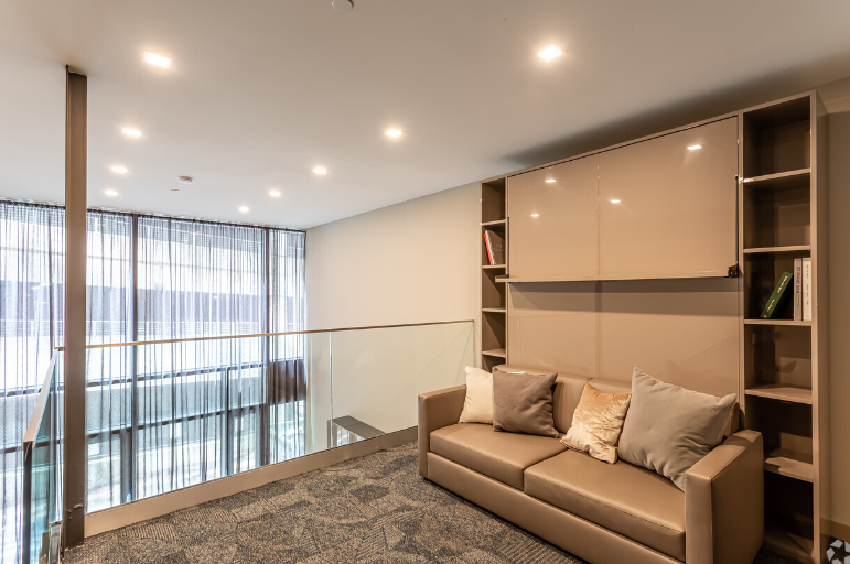A living room with a couch and shelves on the wall