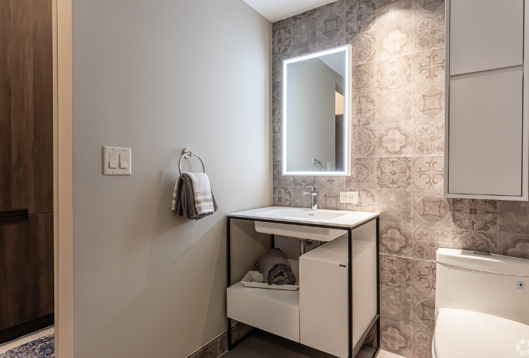 A bathroom with a sink , toilet and mirror.