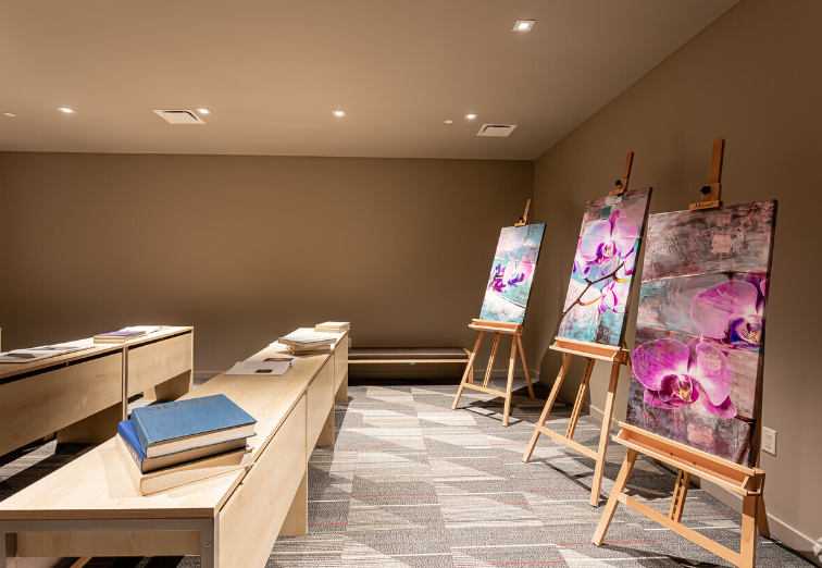 There are three paintings on easels in the room.