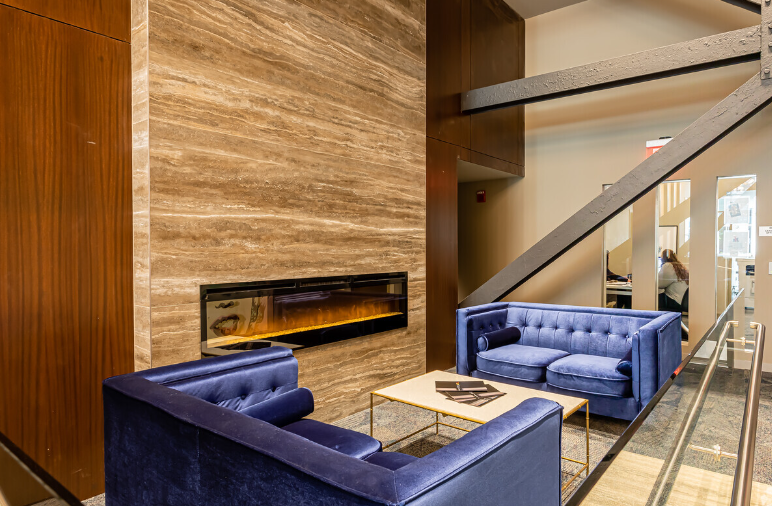 There is a fireplace in the living room with a couch and chairs.