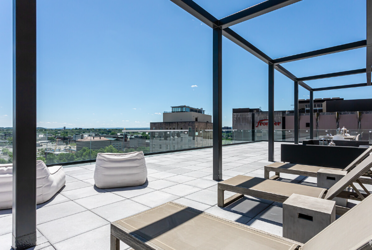There are a lot of chairs on the roof of a building.