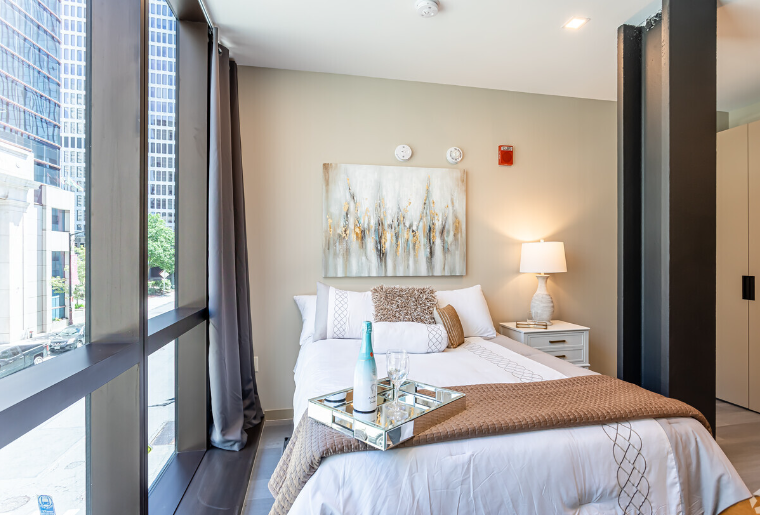 A bedroom with a large bed and a large window.