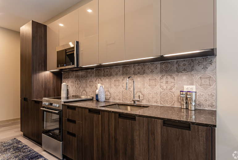 A kitchen with stainless steel appliances and wooden cabinets.