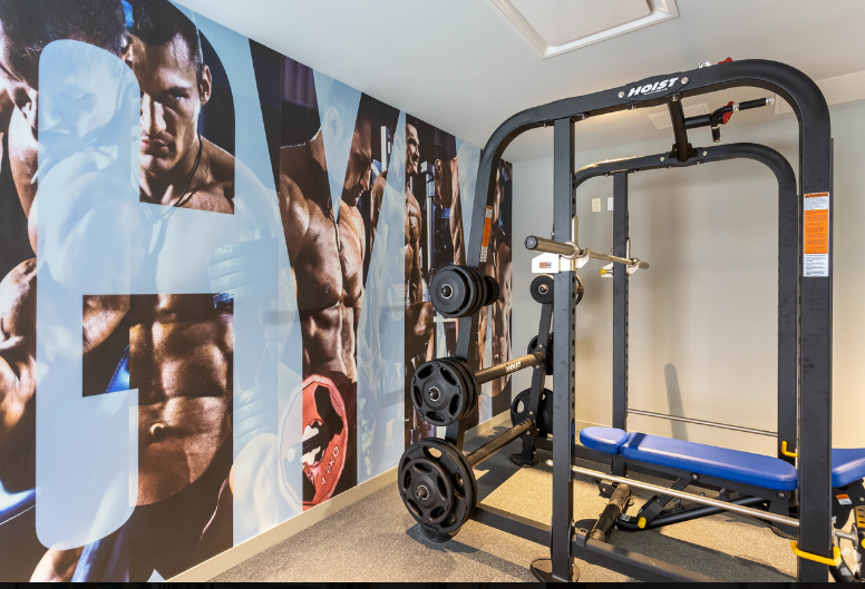 A gym with a picture of a boxer on the wall and a bench.