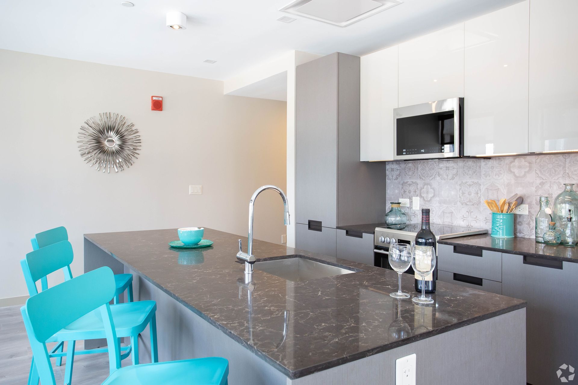 A kitchen with a large island and a bottle of wine on the counter.