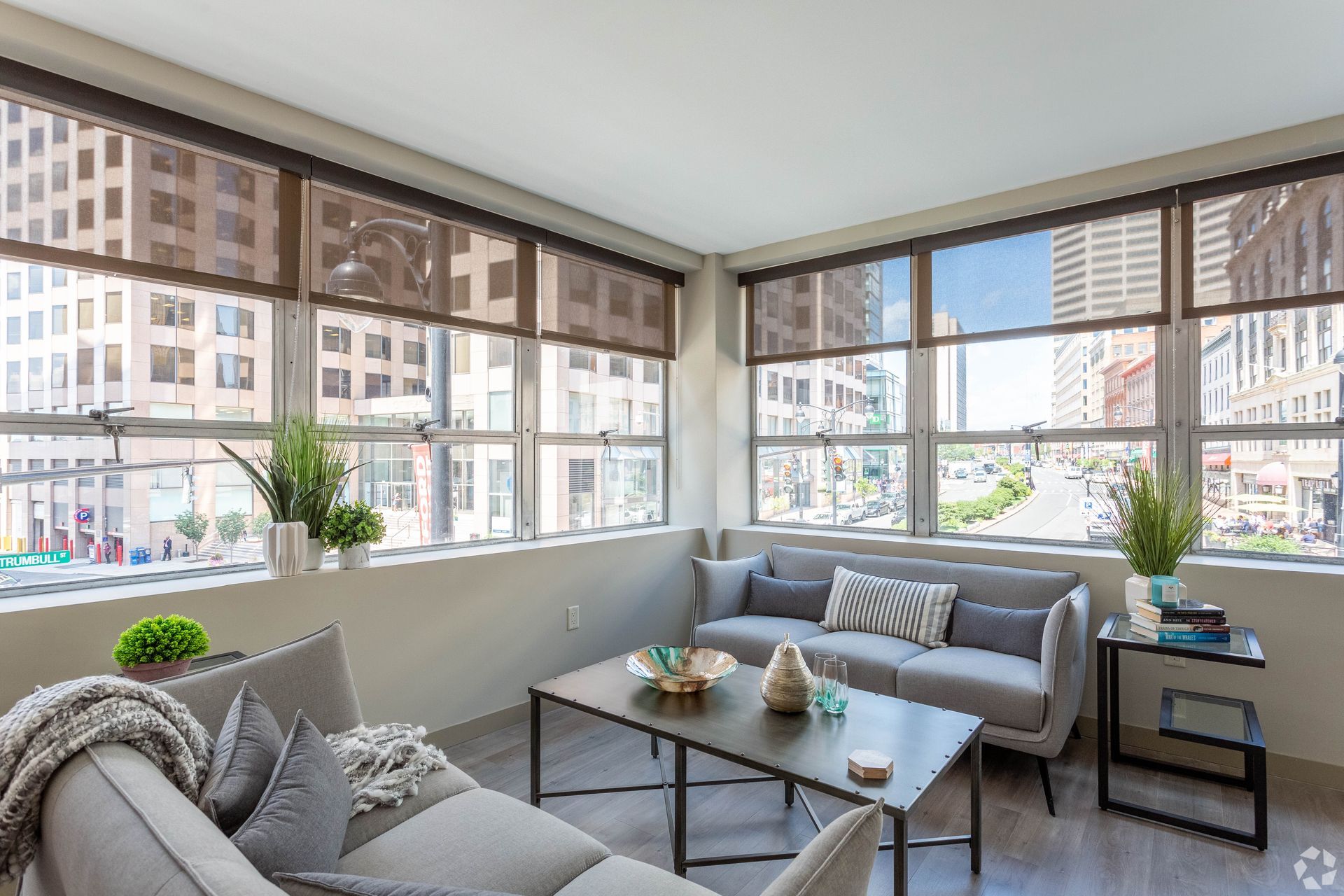 A living room with a couch , coffee table , and lots of windows.