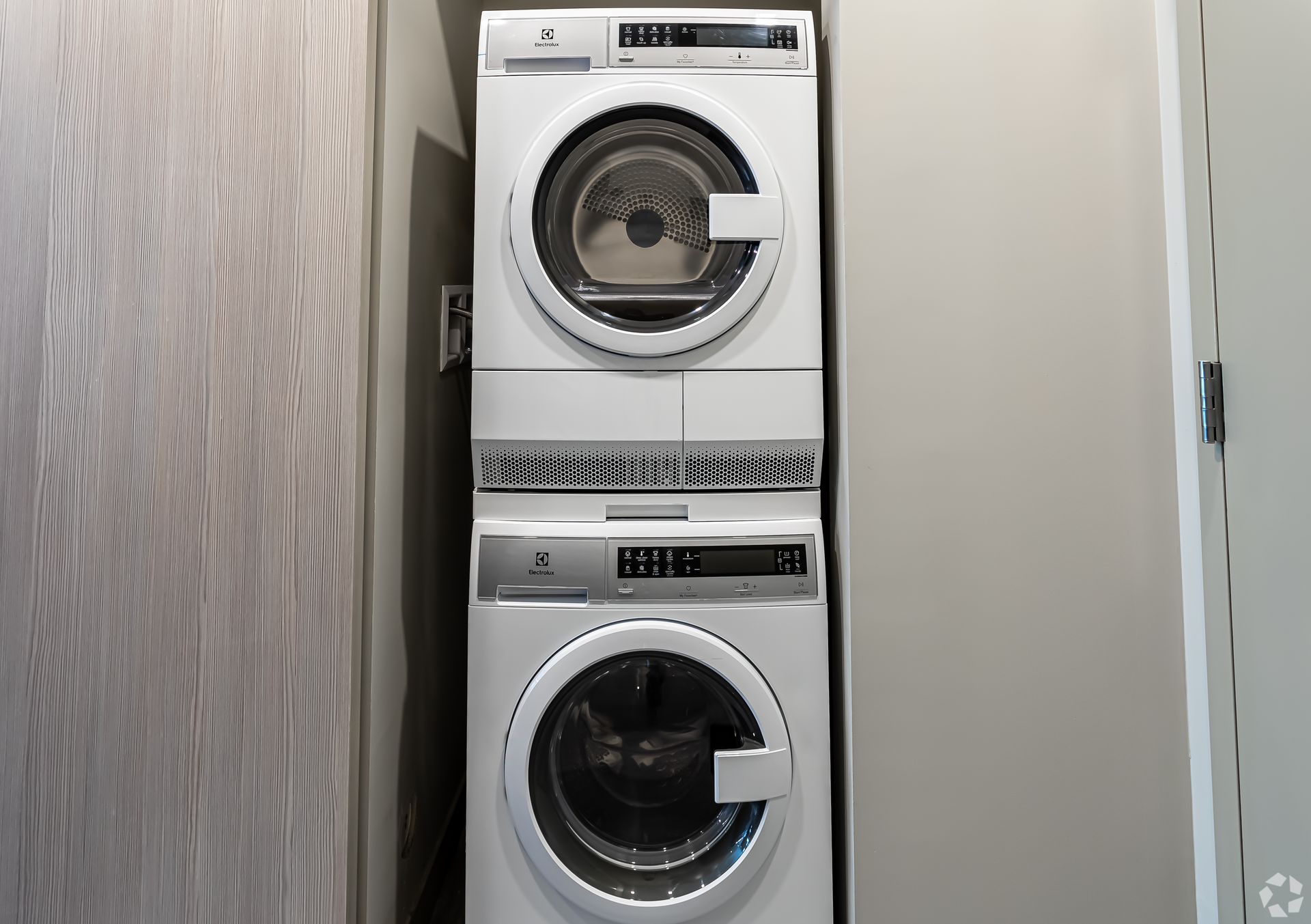 A washer and dryer are stacked on top of each other in a laundry room.
