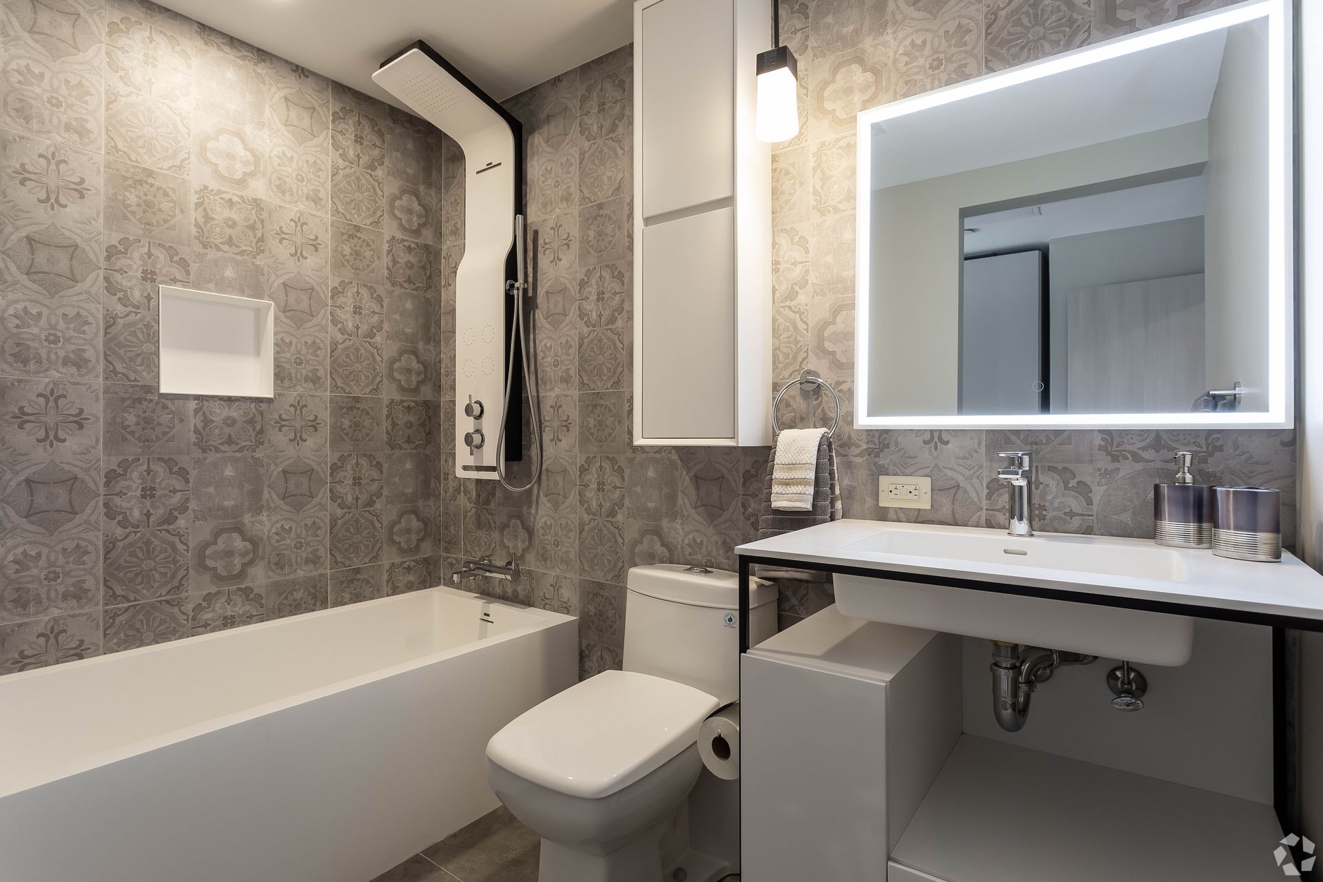 A bathroom with a toilet , sink , bathtub and mirror.