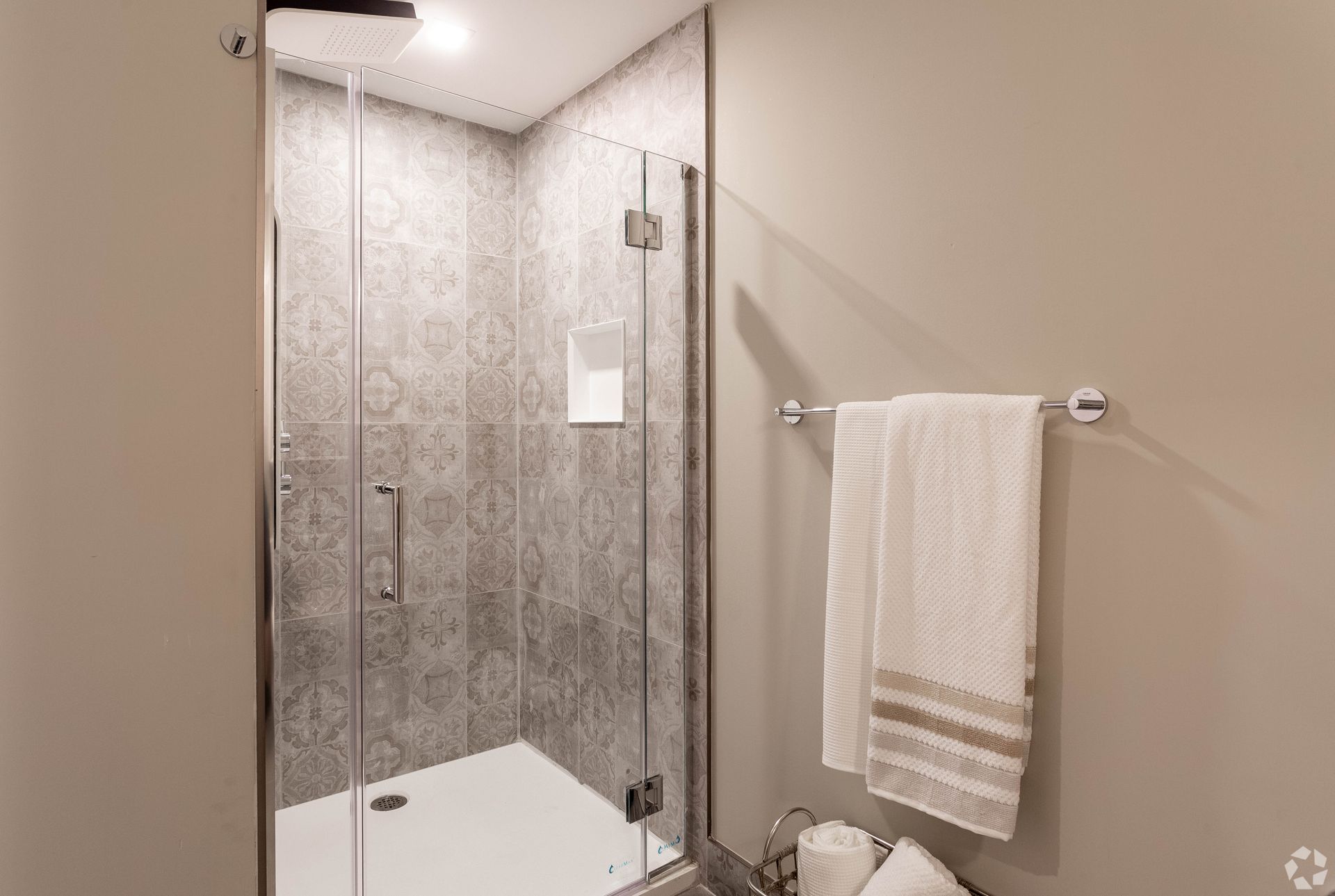 A bathroom with a walk in shower and a towel rack.