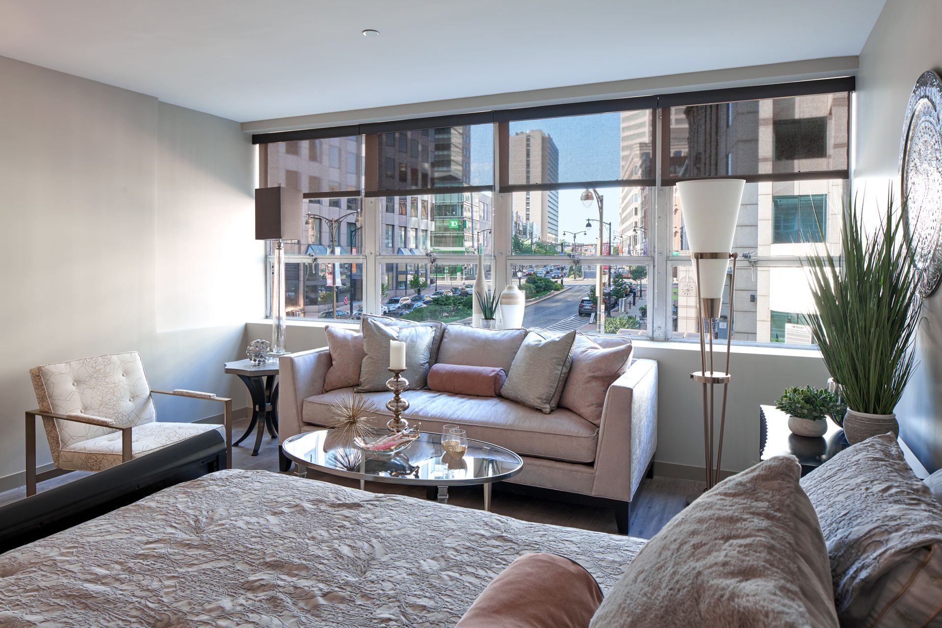 A living room with a couch , chair , table and large windows