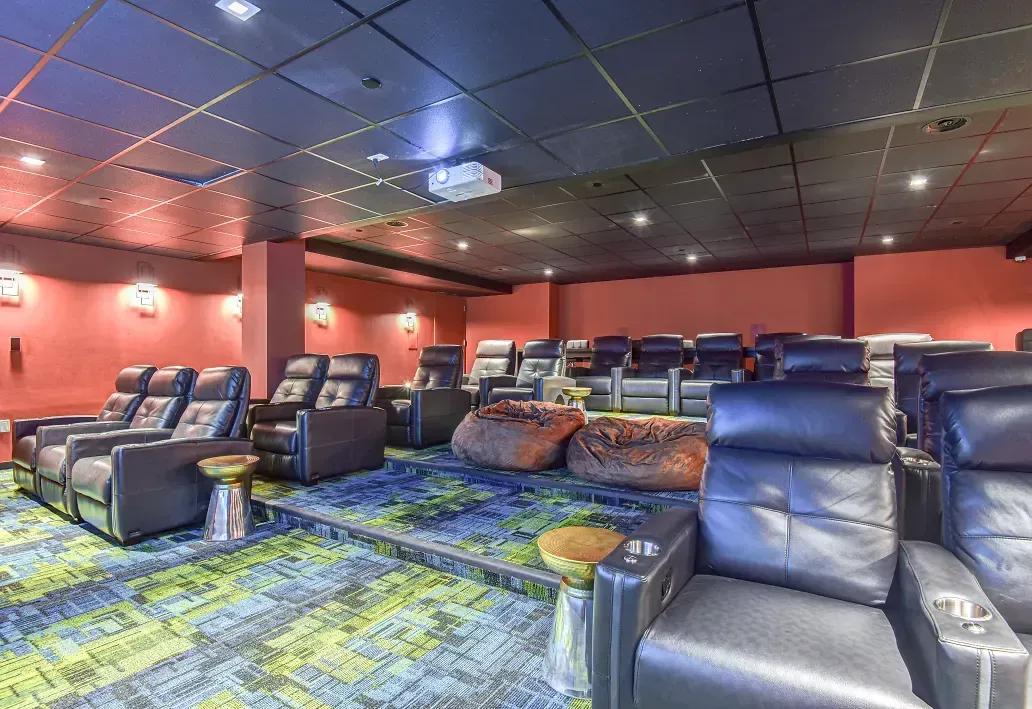 A home theater with lots of chairs and a projector.