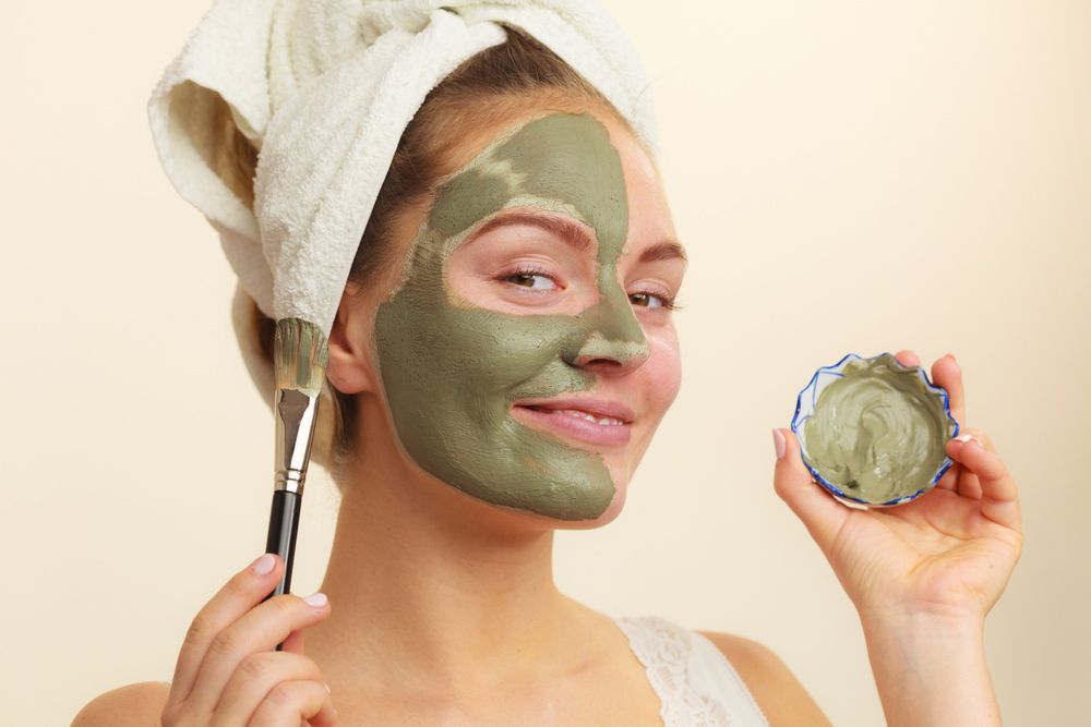 Woman Applying with Brush Clay Mud Mask to Her Face — Bersantai Medispa in Toukley, NSW