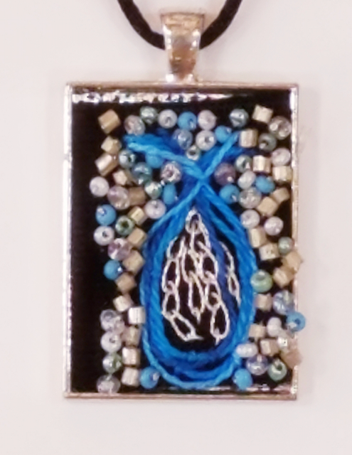 A pendant with a blue and white design on it