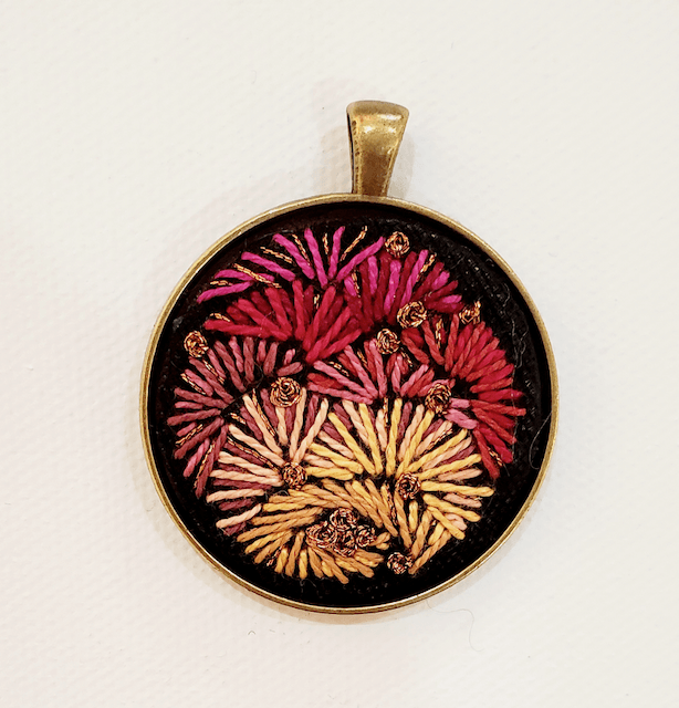 A pendant with a floral design on it