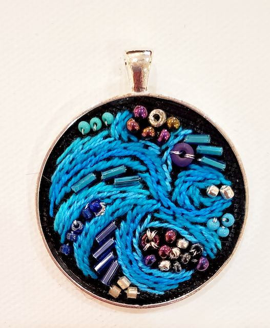 A pendant with blue and purple beads on it