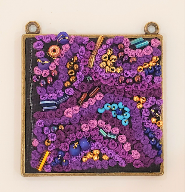 A picture of purple and blue beads on a chalkboard