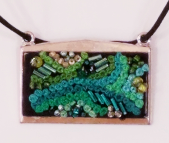 A necklace with green and blue beads on it