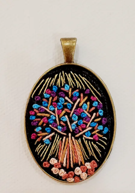 A pendant with a tree embroidered on it