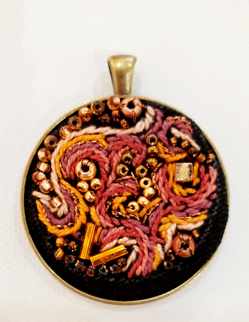 A pendant with a floral design on it