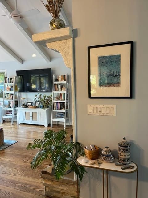 A living room with a table and a picture on the wall