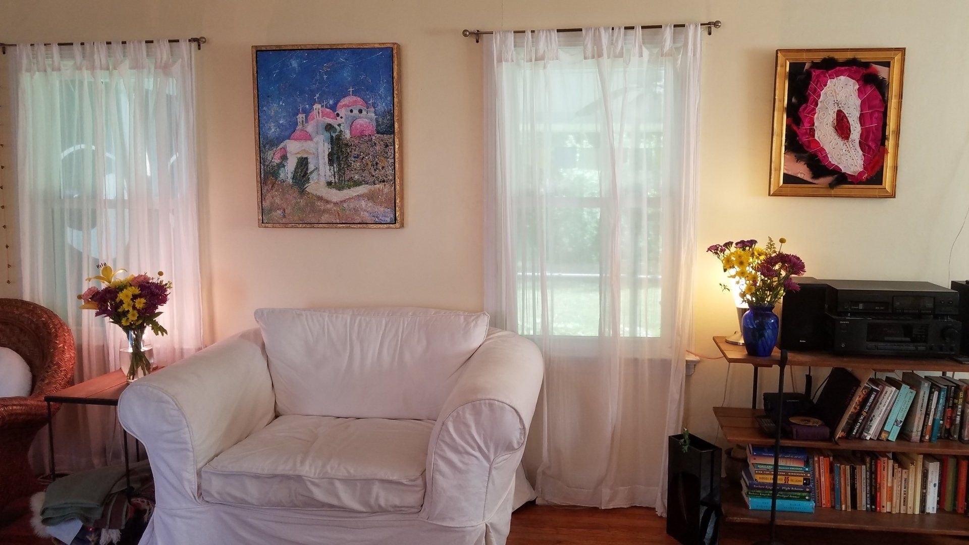 A living room with a white couch and a painting on the wall