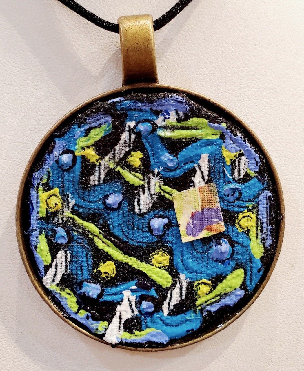 A pendant with a blue and yellow design on it